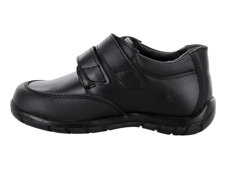 Zapato infantil color negro de material sintético con cierre de velcro.