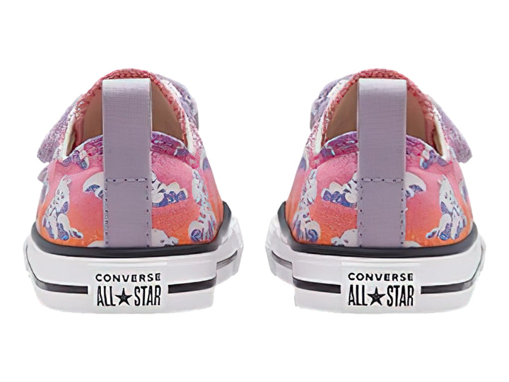 Tenis Converse infantiles rosa y morado con estampado de gatos y nubes, cierre de velcro y suela blanca.