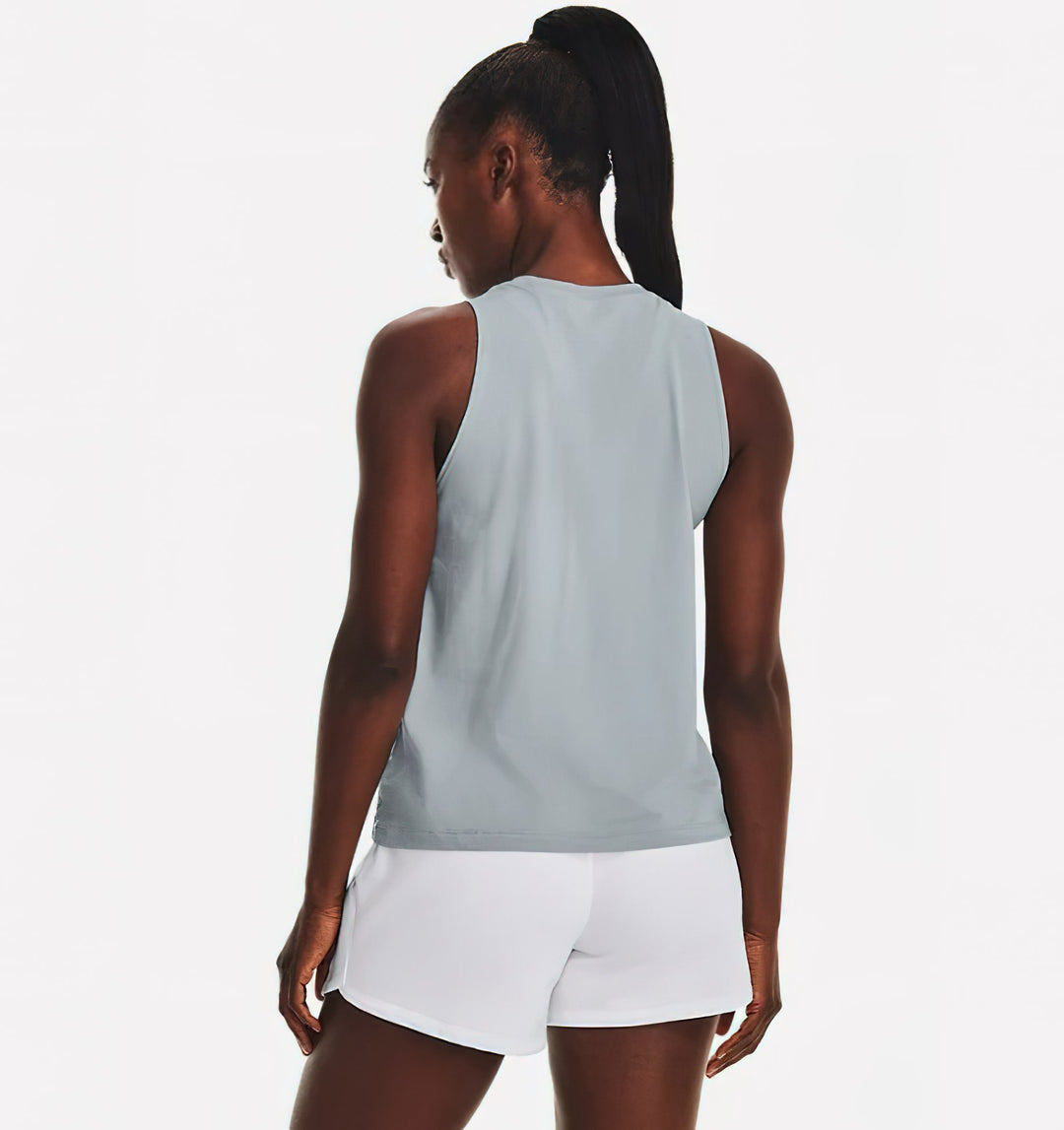 Mujer vistiendo una camiseta sin mangas azul claro de Under Armour y shorts blancos.