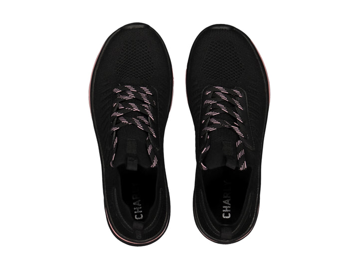 Tenis deportivos Charly en color negro con detalles y franja en la suela de color rosa.