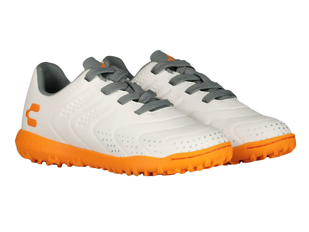 Tenis de fútbol Charly color blanco con suela naranja y detalles en gris.