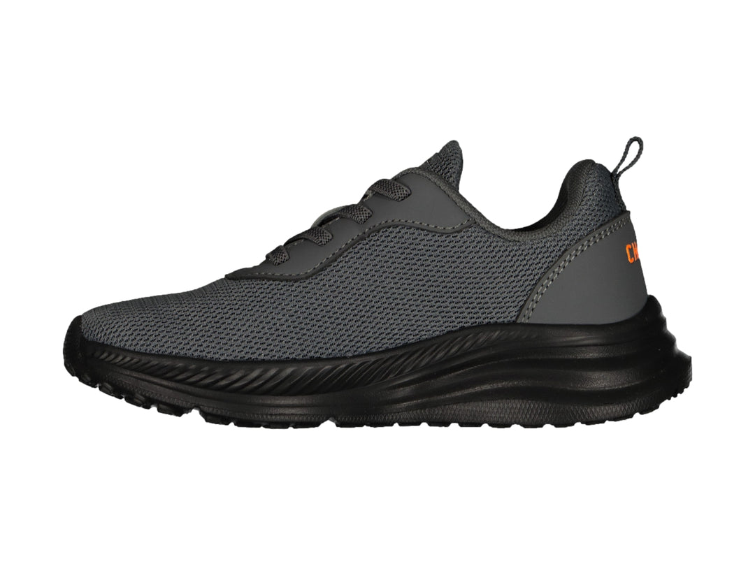 Tenis deportivos Charly color gris oscuro con suela negra y detalle naranja en el costado.
