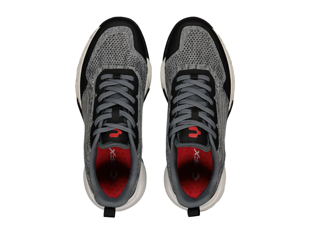 Tenis deportivos Charly color gris y negro con detalles en rojo y suela blanca.