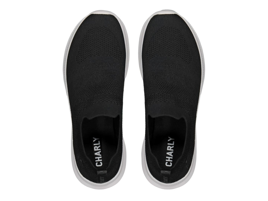 Par de tenis deportivos Charly estilo slip-on en color negro con suela blanca contrastante.
