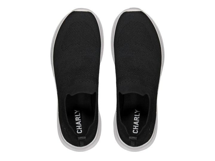 Par de tenis deportivos Charly estilo slip-on en color negro con suela blanca contrastante.