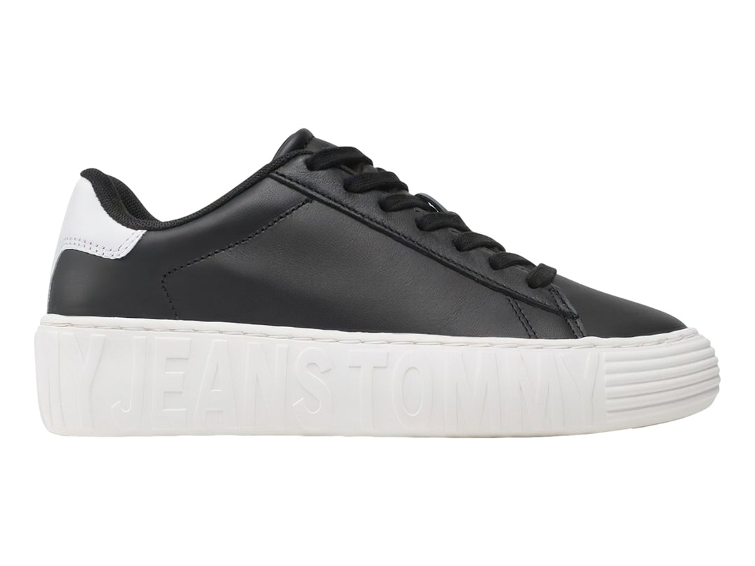 Tenis Tommy Hilfiger de cuero negro con suela ancha blanca y detalles en el talón.
