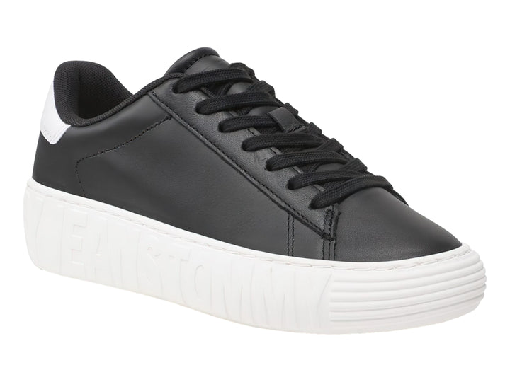 Tenis Tommy Hilfiger de cuero negro con suela ancha blanca y detalles en el talón.