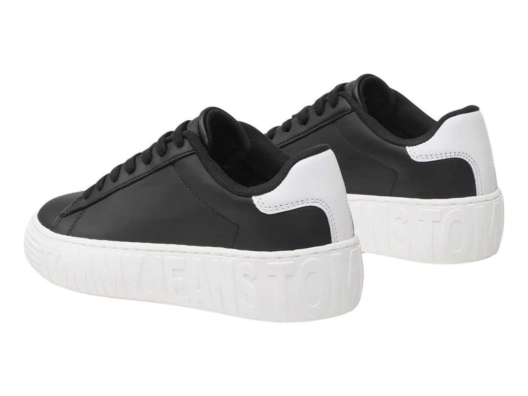 Tenis Tommy Hilfiger de cuero negro con suela ancha blanca y detalles en el talón.