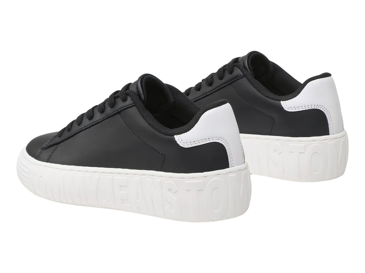 Tenis Tommy Hilfiger de cuero negro con suela ancha blanca y detalles en el talón.