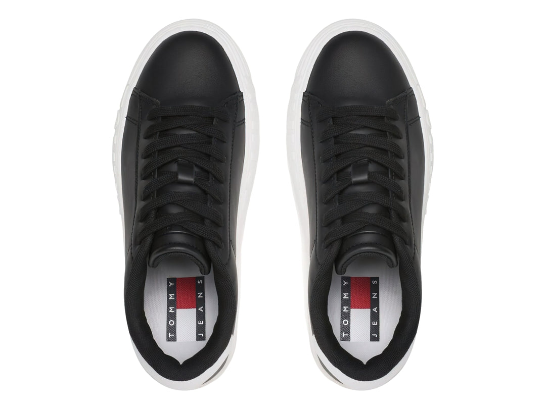 Tenis Tommy Hilfiger de cuero negro con suela ancha blanca y detalles en el talón.