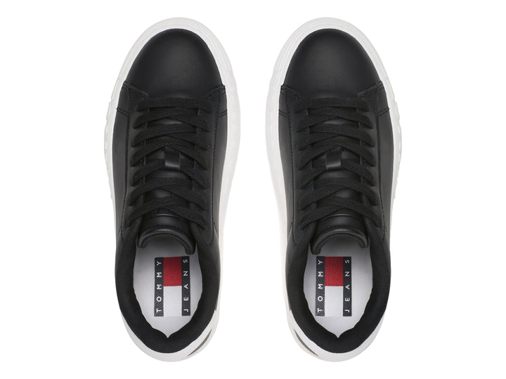 Tenis Tommy Hilfiger de cuero negro con suela ancha blanca y detalles en el talón.