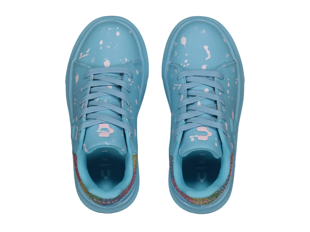 Tenis Charly azul claro con salpicaduras blancas y detalle brillante en el talón.