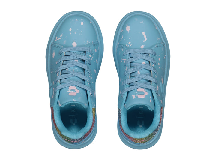 Tenis Charly azul claro con salpicaduras blancas y detalle brillante en el talón.