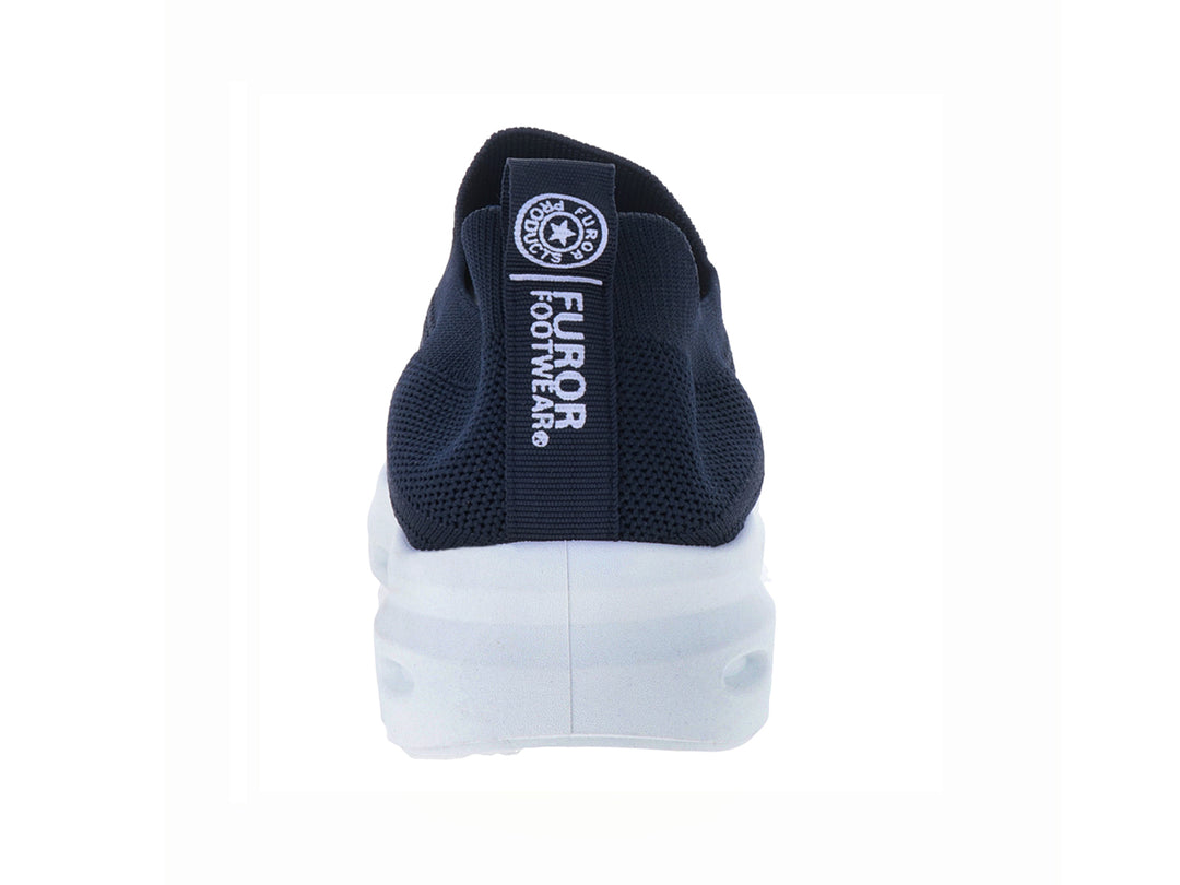Zapato deportivo slip-on de color azul marino con suela blanca gruesa y perforada.