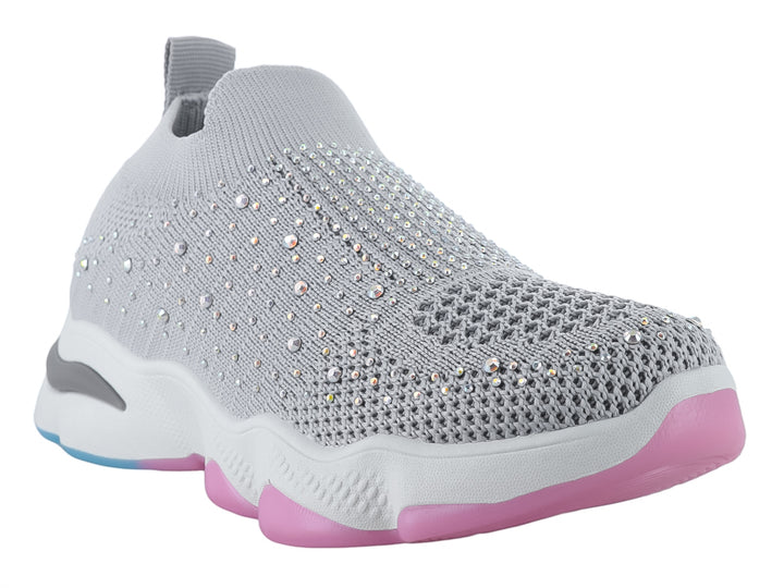 Tenis deportivos infantiles color gris con detalles brillantes y suela blanca con acentos rosa y azul.