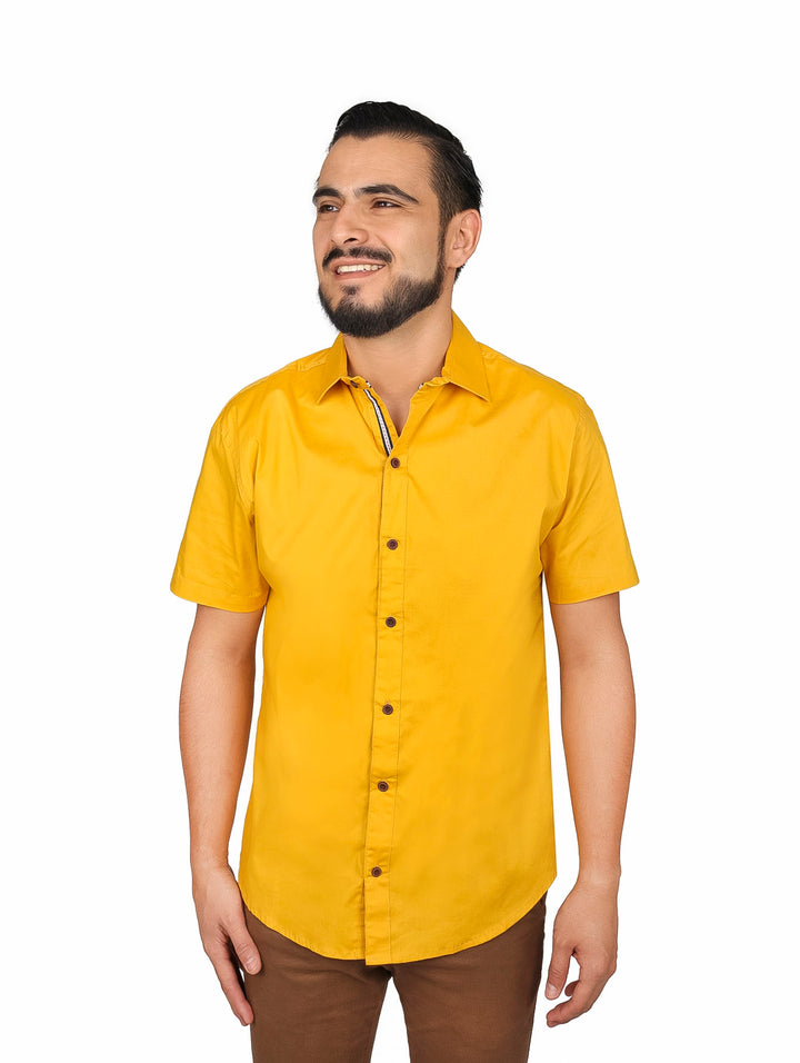Hombre vistiendo una camisa lisa de color mostaza con manga corta y cuello.