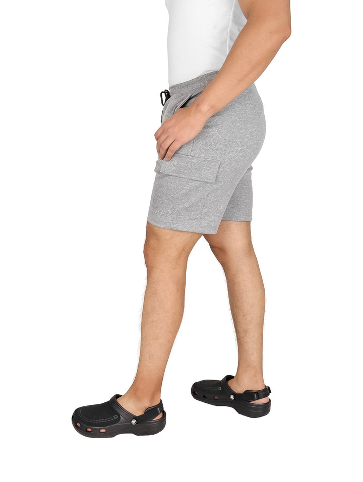 Hombre vistiendo pantalones cortos de color gris con cordón ajustable y bolsillos laterales.