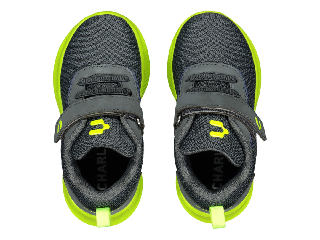 Tenis deportivos infantiles color gris con suela verde lima y cierre de velcro.