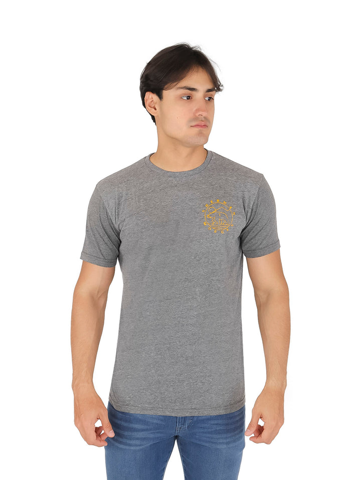 Hombre vistiendo una playera de color gris con manga corta y cuello redondo.