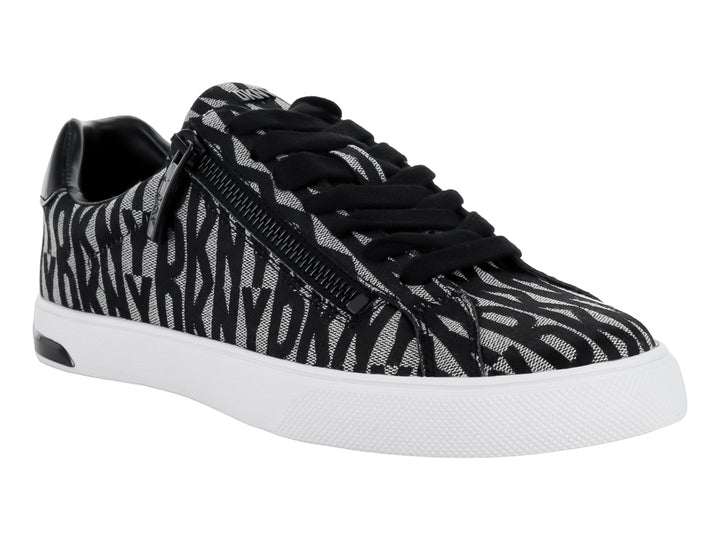 Tenis DKNY con estampado en negro y beige, suela blanca y cierre lateral.