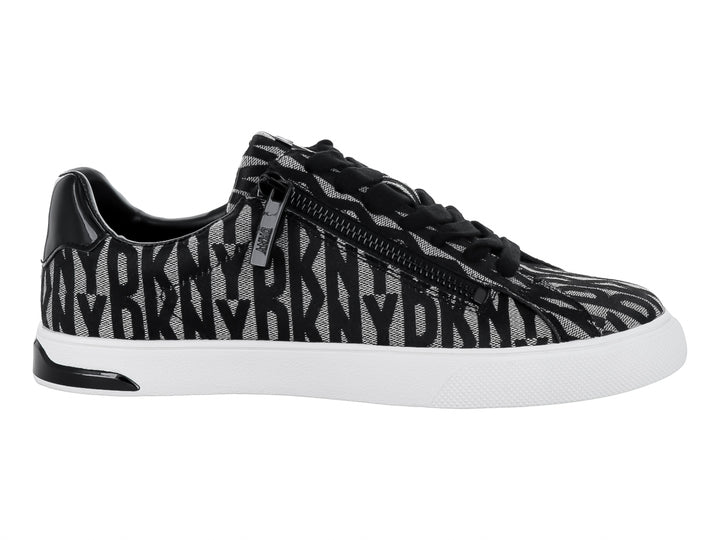 Tenis DKNY con estampado en negro y beige, suela blanca y cierre lateral.