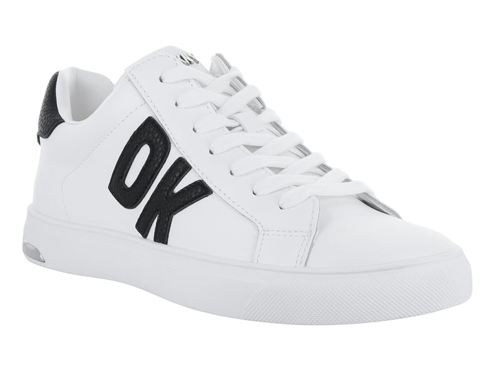 Tenis blancos DKNY con logotipo negro en el lateral y suela blanca.