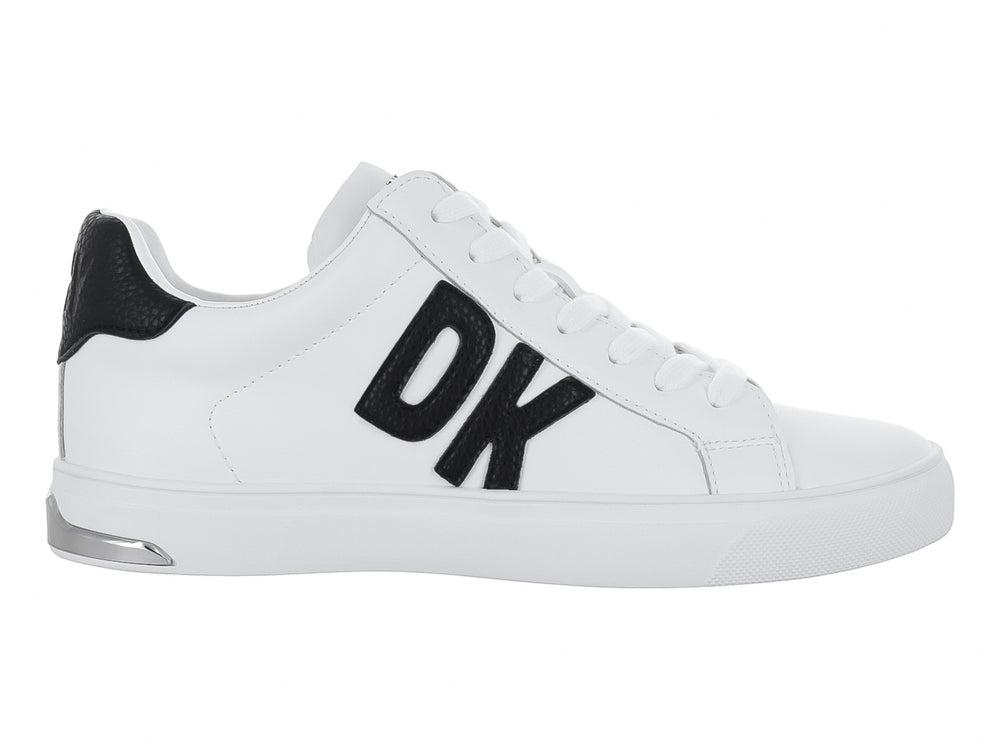 Tenis blancos DKNY con logotipo negro en el lateral y suela blanca.