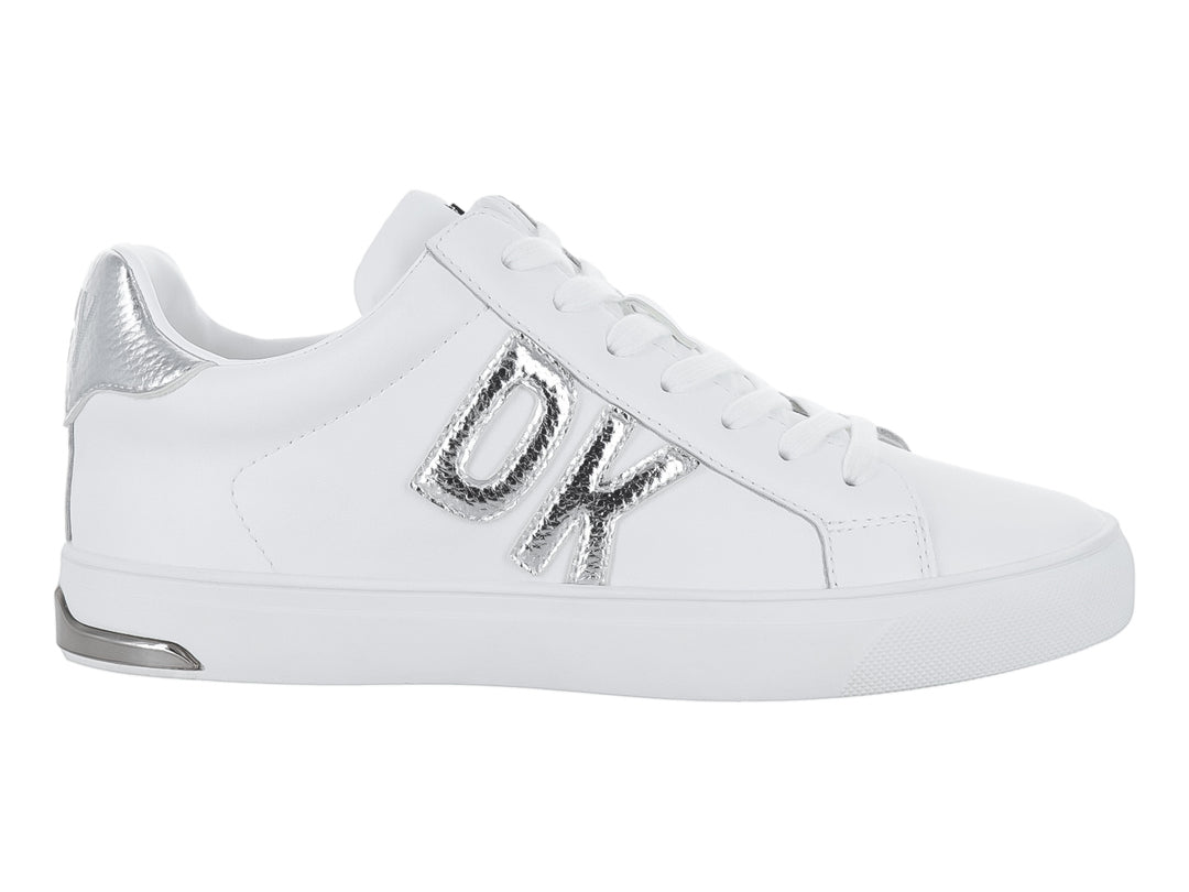 Tenis DKNY color blanco con letras decorativas en color plateado y suela blanca.