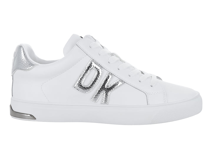 Tenis DKNY color blanco con letras decorativas en color plateado y suela blanca.
