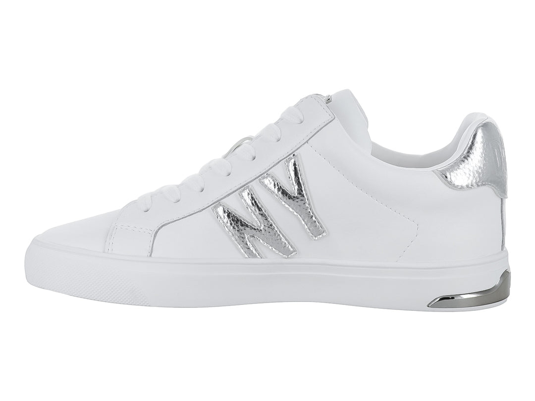 Tenis DKNY color blanco con letras decorativas en color plateado y suela blanca.