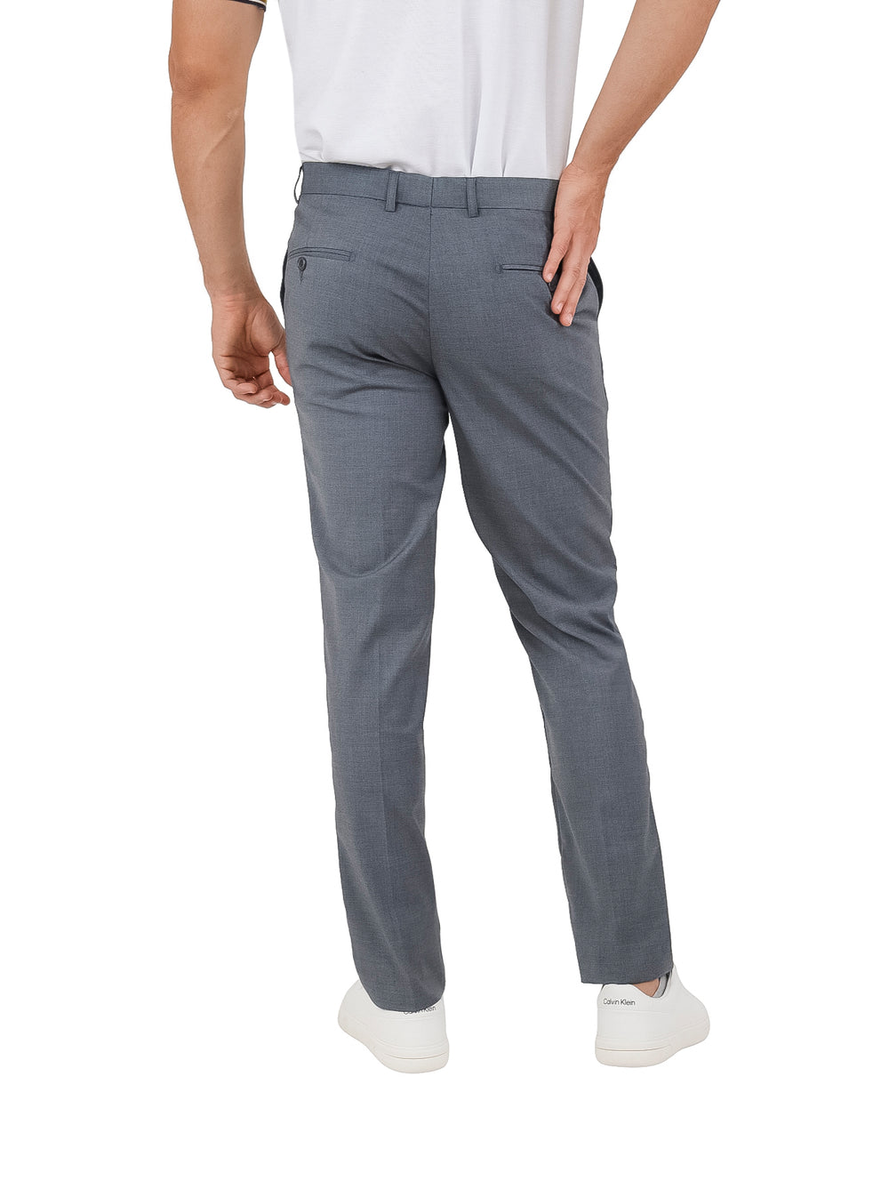 Hombre vistiendo un pantalón de gabardina color gris lead grey y tenis blancos.