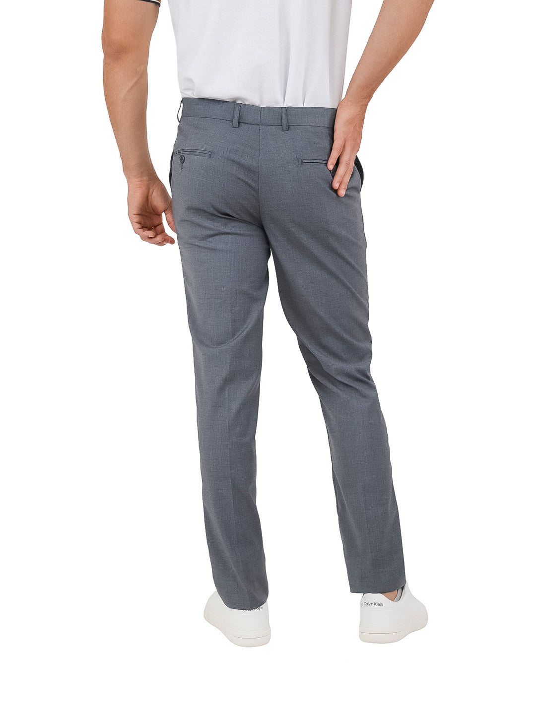 Hombre vistiendo un pantalón de gabardina color gris lead grey y tenis blancos.