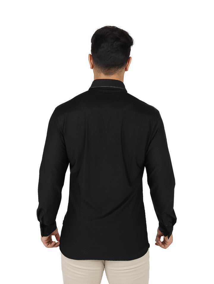 Hombre vistiendo una camisa negra de manga larga y cuello, estilo elegante.