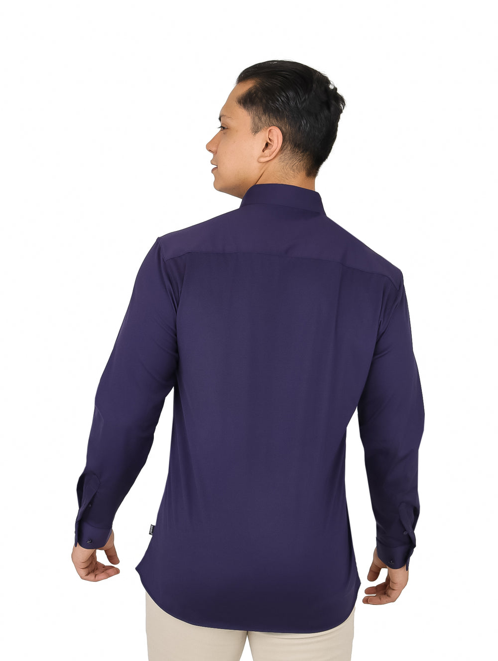 Hombre vistiendo una camisa de manga larga color azul marino lisa con cuello y botones.