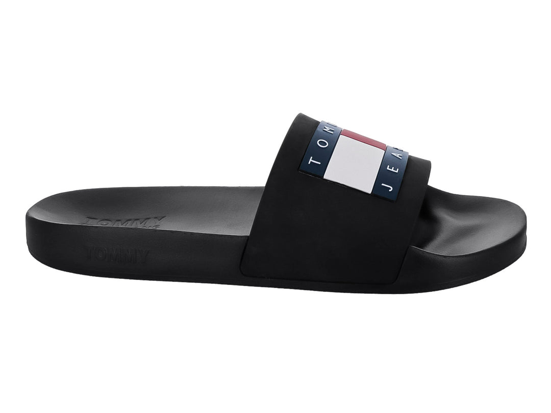 Sandalia slide negra de Tommy Jeans con banda ancha y detalle tricolor en la parte superior.