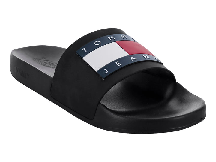 Sandalia slide negra de Tommy Jeans con banda ancha y detalle tricolor en la parte superior.