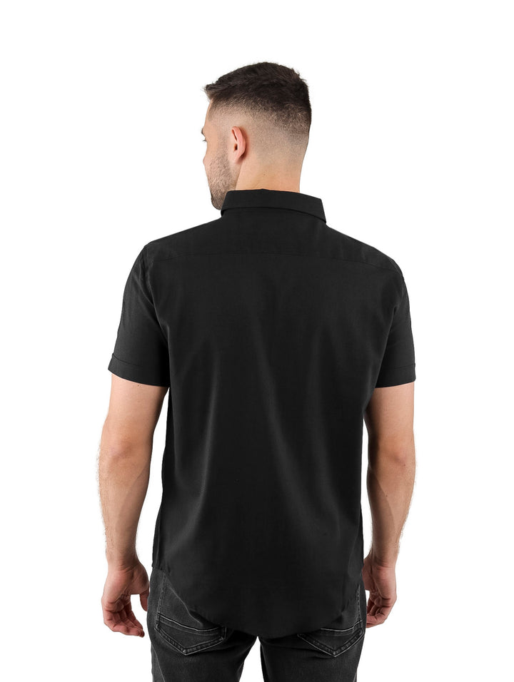 Hombre vistiendo una camisa negra de manga corta con botones y cuello.