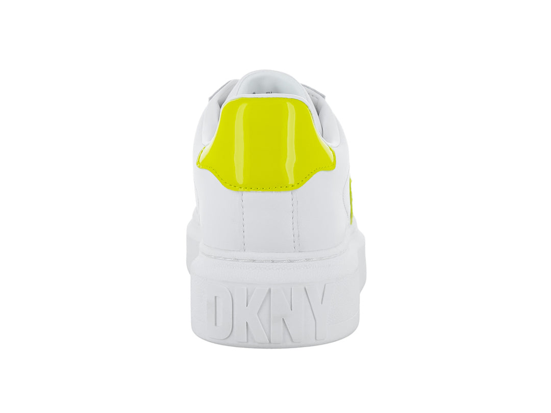 Tenis blancos de plataforma con letras DK en color amarillo chartreuse en el lateral.