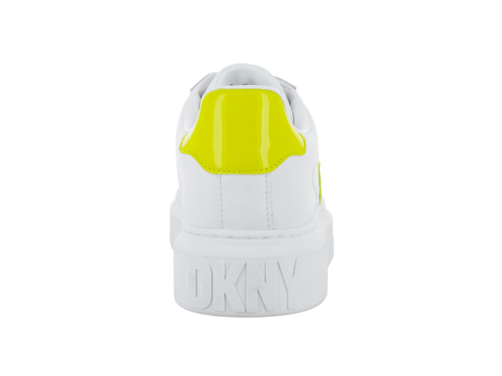 Tenis blancos de plataforma con letras DK en color amarillo chartreuse en el lateral.