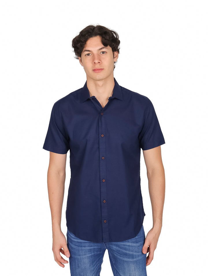 Hombre vistiendo una camisa lisa de color azul marino con manga corta y cuello.