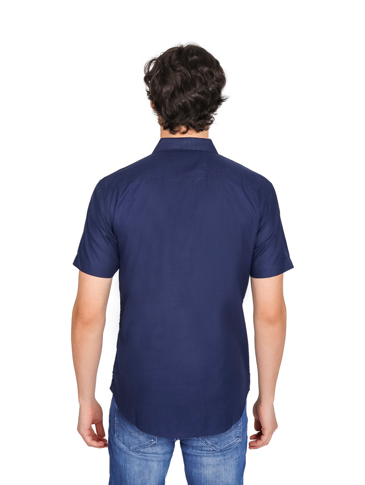 Hombre vistiendo una camisa lisa de color azul marino con manga corta y cuello.