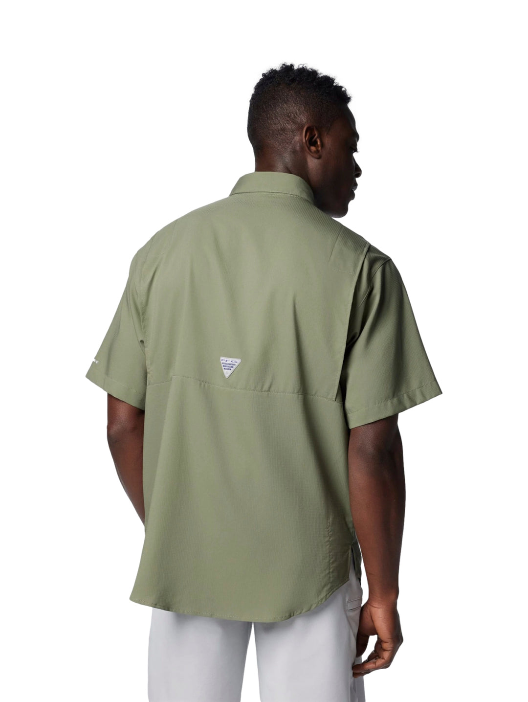 Hombre vistiendo camisa Columbia de manga corta en color verde Cypress con bolsillos frontales.