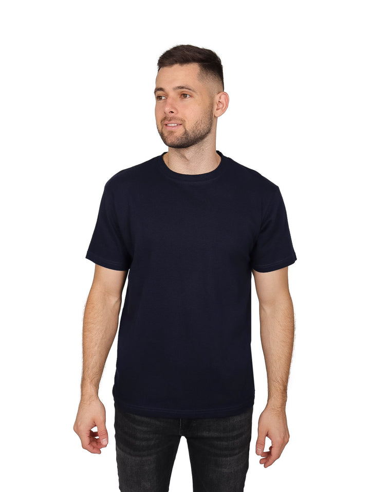 Hombre vistiendo una playera básica de manga corta en color azul marino.