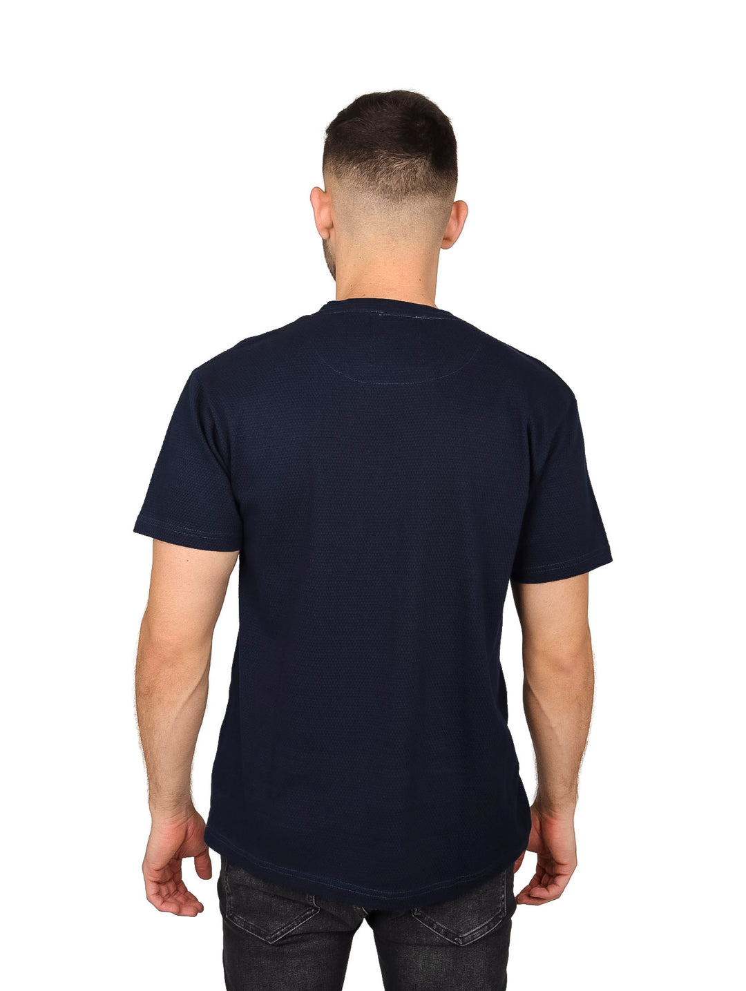 Hombre vistiendo una playera básica de manga corta en color azul marino.