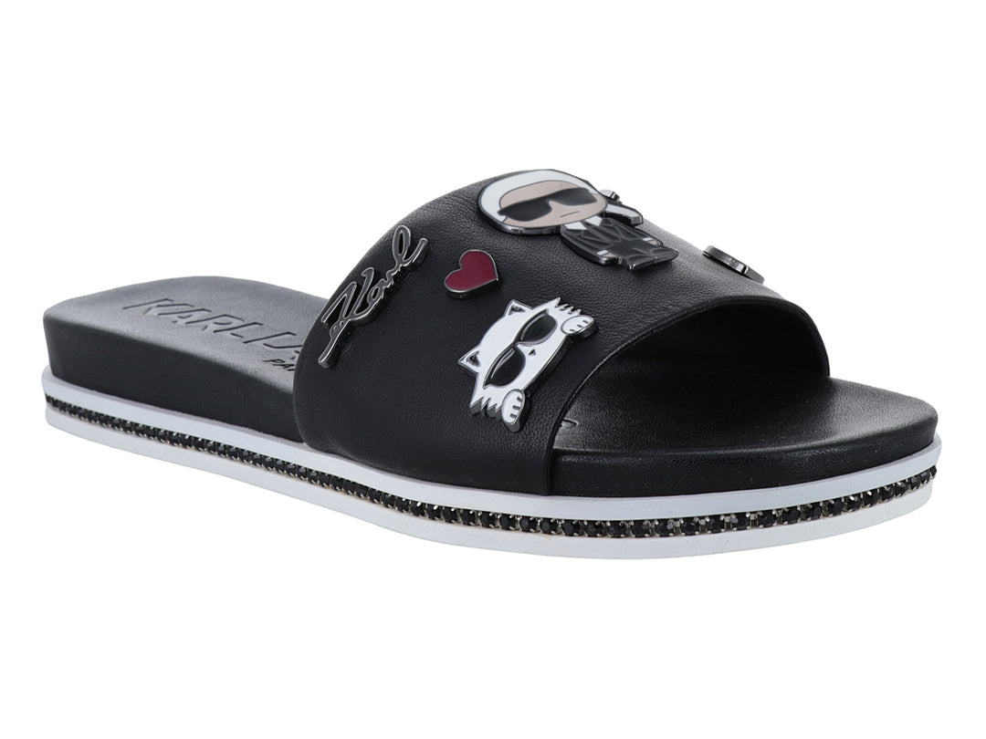 Sandalia slide negra con parches decorativos y suela blanca con detalles brillantes.