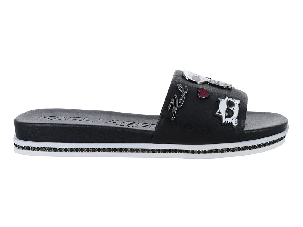 Sandalia slide negra con parches decorativos y suela blanca con detalles brillantes.