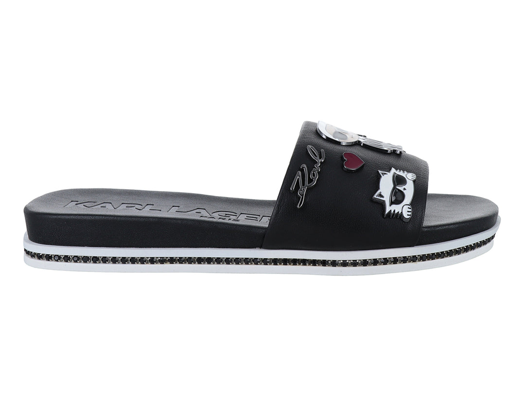 Sandalia slide negra con parches decorativos y suela blanca con detalles brillantes.