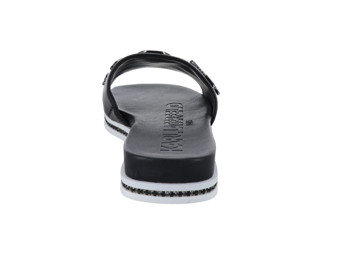 Sandalia slide negra con parches decorativos y suela blanca con detalles brillantes.