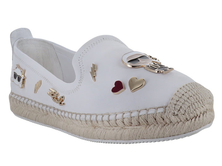 Zapato blanco tipo alpargata con suela de yute y detalles metálicos decorativos.