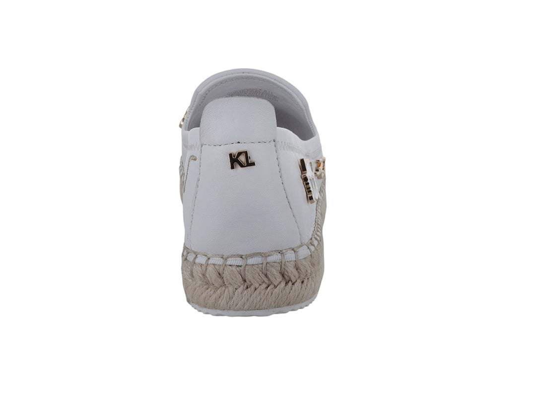 Zapato blanco tipo alpargata con suela de yute y detalles metálicos decorativos.